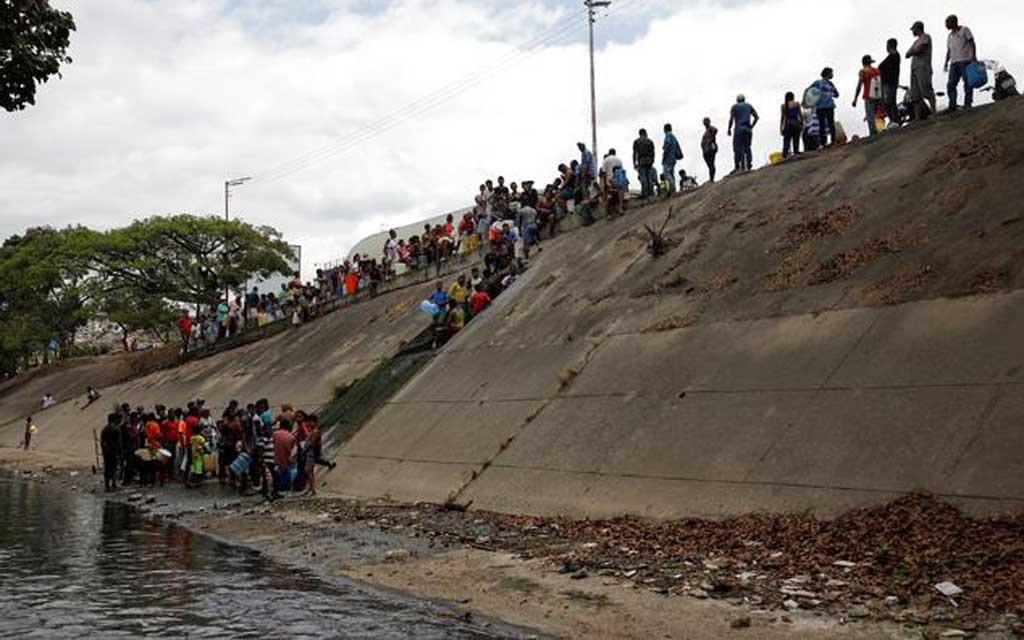 Desperate Venezuelans swarm sewage drains in search of water